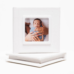 Capa revestida em couro sintético branco, com janela em moldura de acrílico branco.